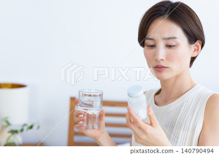 中年婦女服用補品的婦女 中年婦女服用補品的婦女 140790494