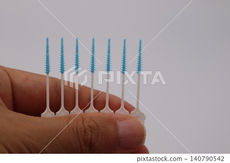 Person holding an interdental brush Person holding an interdental brush 140790542