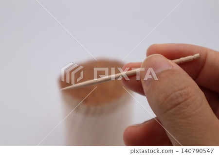 A person holding a toothpick A person holding a toothpick 140790547