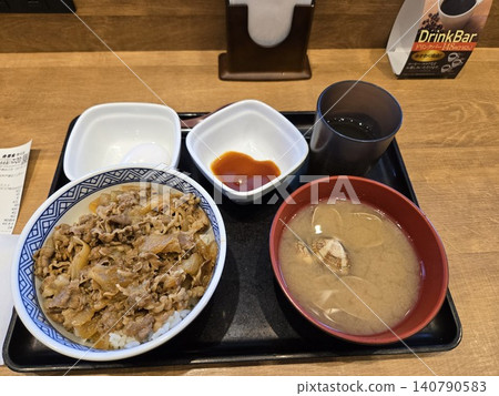 A set meal consisting of beef bowl, miso soup, and a soft-boiled egg served on a tray. A set meal consisting of beef bowl, miso soup, and a soft-boiled egg served on a tray. 140790583