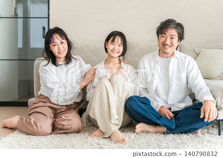 Parents and children, families, sitting in the living room of their home 140790832