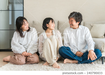 A family, parent and child, relaxing in the living room of their home. A family, parent and child, relaxing in the living room of their home. 140790833