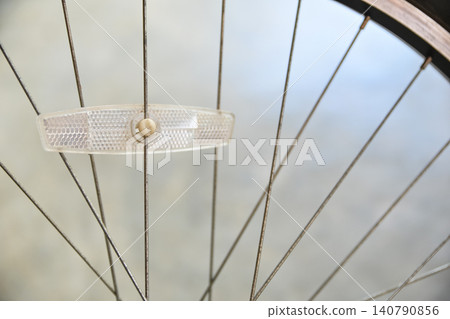 plastic spoke reflector mounted on a bicycle wheel, focusing on cycling safety equipment. 140790856