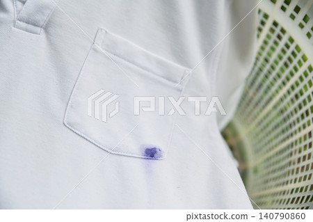 White cotton shirt stained with blue or purple ballpoint pen ink. Cleaning, washing problem, and housework accident concept. White cotton shirt stained with blue or purple ballpoint pen ink. Cleaning, washing problem, and housework accident concept. 140790860