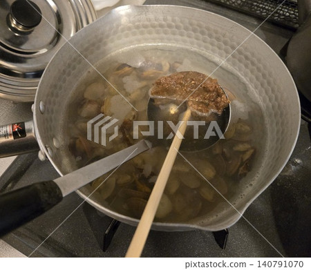 Making miso soup with clams and surf clams; the moment miso is dissolved in the pot. Making miso soup with clams and surf clams; the moment miso is dissolved in the pot. 140791070