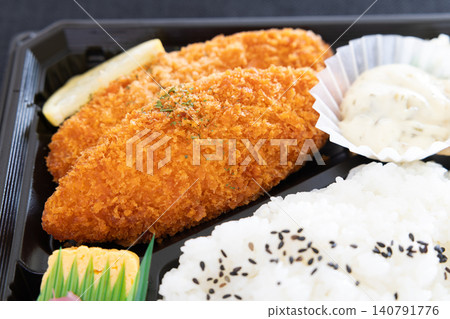 A bento box with delicious fried white fish and tartar sauce. 140791776