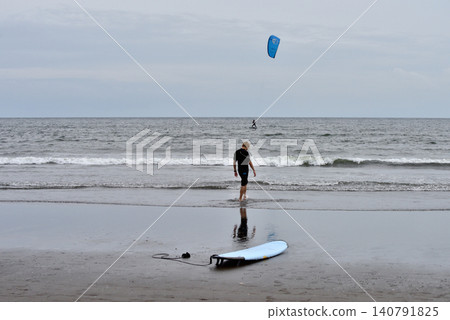 A surfboard and a man on the beach at Kugenuma Beach A surfboard and a man on the beach at Kugenuma Beach 140791825