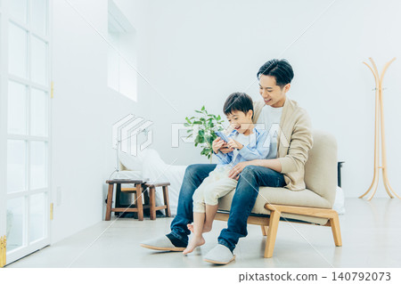 A young family looking at a smartphone in the living room 140792073