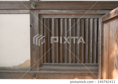 A traditional Japanese building with wooden latticework and peeling plaster walls remaining. A traditional Japanese building with wooden latticework and peeling plaster walls remaining. 140792411