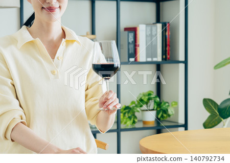 一位年輕女子在家喝紅酒時的手 一位年輕女子在家喝紅酒時的手 140792734