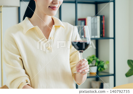 一位年輕女子在家喝紅酒時的手 一位年輕女子在家喝紅酒時的手 140792735