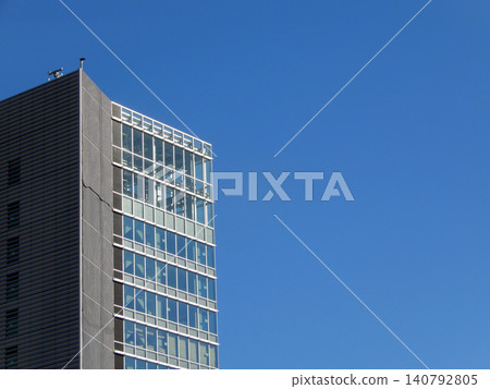 Office building with the blue sky reflected in the windowpanes 140792805