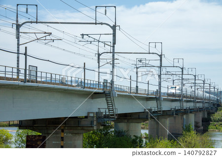 東海道新幹線運行在橫跨河流的高架橋上。 東海道新幹線運行在橫跨河流的高架橋上。 140792827