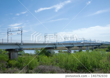 東海道新幹線運行在橫跨河流的高架橋上。 140792830