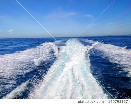 White waves from a speedboat against a blue sky 140793167