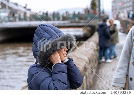 Winter canal and a woman in winter clothing Winter canal and a woman in winter clothing 140793289