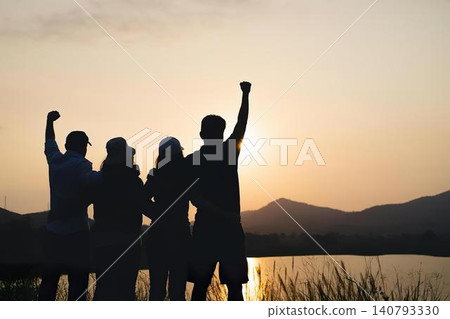 Group of people celebrating outdoors at sunset Group of people celebrating outdoors at sunset 140793330