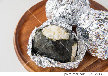 A rice ball made with partially milled rice and moist seaweed. A rice ball made with partially milled rice and moist seaweed. 140793383