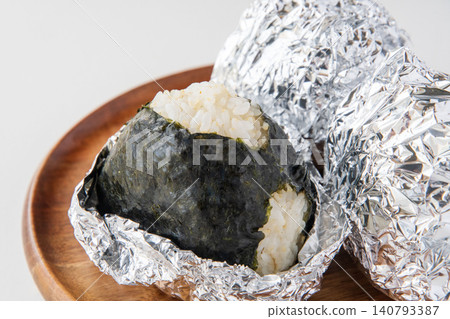A rice ball made with partially milled rice and moist seaweed. 140793387