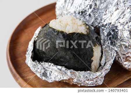 A rice ball made with partially milled rice and moist seaweed. A rice ball made with partially milled rice and moist seaweed. 140793401