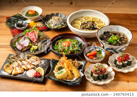 居酒屋的桌子上擺滿了各種精緻的日式單點菜餚和海鮮菜餚。 居酒屋的桌子上擺滿了各種精緻的日式單點菜餚和海鮮菜餚。 140793413