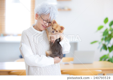 與她的寵物狗一起放鬆的老婦人 與她的寵物狗一起放鬆的老婦人 140793519