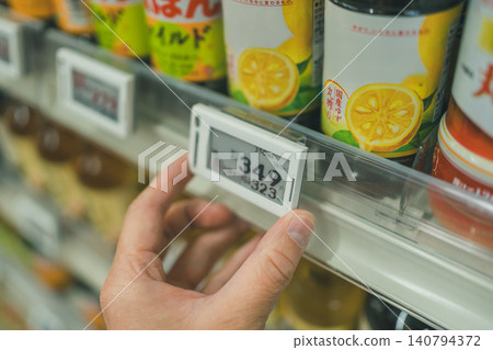 Close-up of a supermarket employee installing electronic shelf labels. 140794372