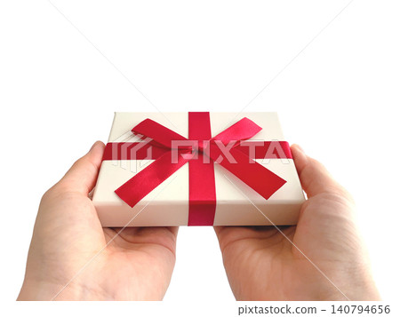 A woman's hand offering a gift with a red ribbon. A woman's hand offering a gift with a red ribbon. 140794656