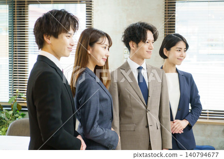 Profiles of a Japanese man and woman standing side by side in an office. 140794677