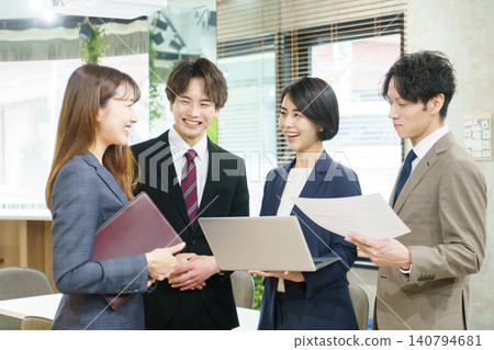 Four young Japanese men and women having a meeting in the office. Four young Japanese men and women having a meeting in the office. 140794681