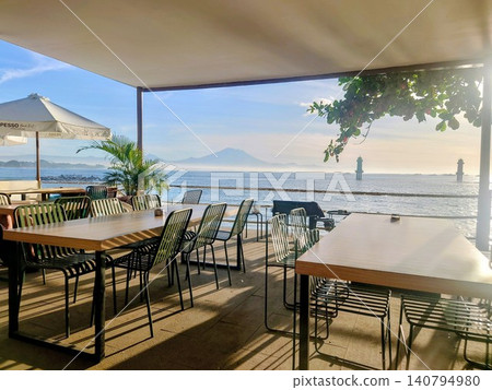 A stylish open-air cafe terrace with panoramic views of Mount Agung and the beautiful sea in Bali. A stylish open-air cafe terrace with panoramic views of Mount Agung and the beautiful sea in Bali. 140794980