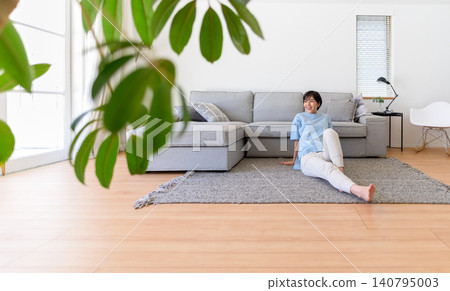 A relaxed woman unwinding on the living room floor. A relaxed woman unwinding on the living room floor. 140795003