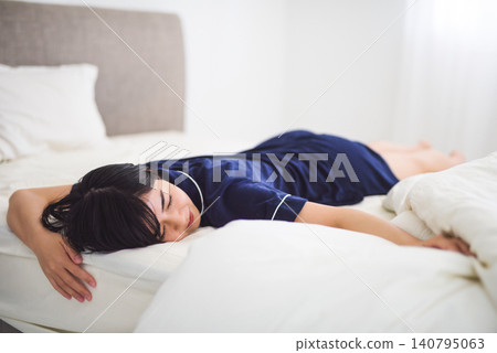 A young woman lying in bed and resting. A young woman lying in bed and resting. 140795063
