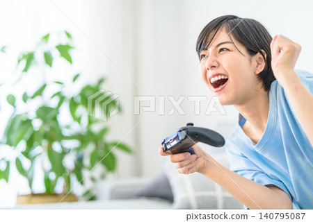 A young woman is happy after winning a game. A young woman is happy after winning a game. 140795087