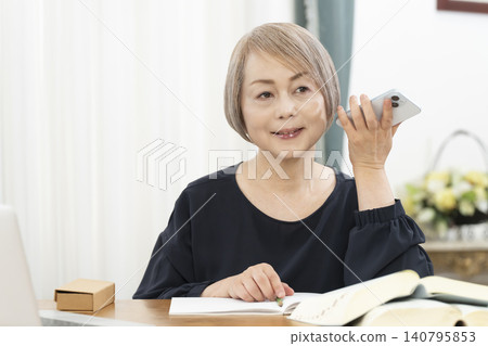老年婦女透過智慧型手機學習英語會話 老年婦女透過智慧型手機學習英語會話 140795853