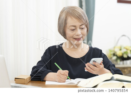Senior women learning English conversation on their smartphones Senior women learning English conversation on their smartphones 140795854