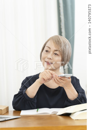 老年婦女透過智慧型手機學習英語會話 老年婦女透過智慧型手機學習英語會話 140795873