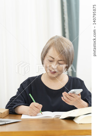 老年婦女透過智慧型手機學習英語會話 老年婦女透過智慧型手機學習英語會話 140795875