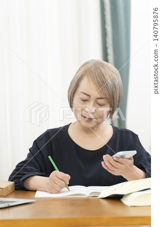 老年婦女透過智慧型手機學習英語會話 老年婦女透過智慧型手機學習英語會話 140795876