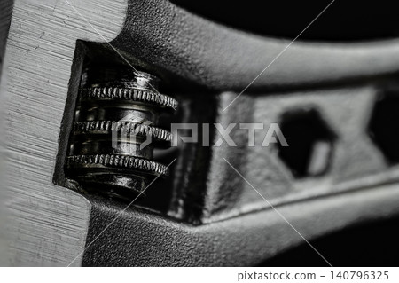 Macro view shows adjustable wrench head, toothed worm gear, and open jaw against dark background, emphasizing rugged steel texture and mechanical precision Macro view shows adjustable wrench head, toothed worm gear, and open jaw against dark background, emphasizing rugged steel texture and mechanical precision 140796325