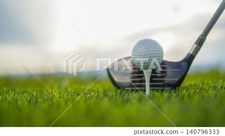 Golf clubs and balls on a green lawn in a beautiful golf course with morning sunshine. Golf clubs and balls on a green lawn in a beautiful golf course with morning sunshine. 140796333