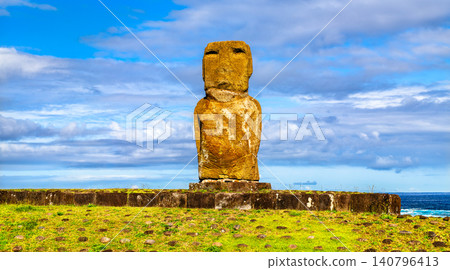 A single ancient stone Moai statue stands on a traditional stone platform at Ahu Riata in Hanga Roa, Easter Island, Chile. 140796413