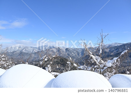 前景中堆積潔白的積雪,遠處是綿延起伏的雪山。 前景中堆積潔白的積雪,遠處是綿延起伏的雪山。 140796881