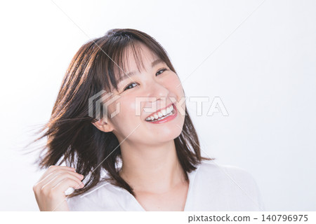 A woman with hair stroking in the wind A woman with hair stroking in the wind 140796975