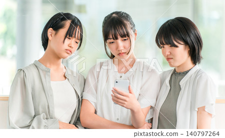 A girl in elementary school or junior high school dressed in casual clothes looking sulky while looking at her smartphone (dissatisfaction, stress, sigh) A girl in elementary school or junior high school dressed in casual clothes looking sulky while looking at her smartphone (dissatisfaction, stress, sigh) 140797264