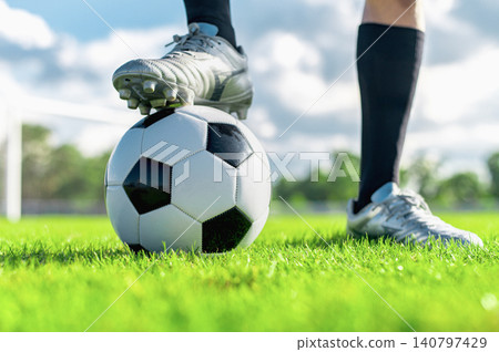 Low Angle Close-up of Football Player Wearing Silver Cleat Boot with Foot on Soccer Ball Low Angle Close-up of Football Player Wearing Silver Cleat Boot with Foot on Soccer Ball 140797429