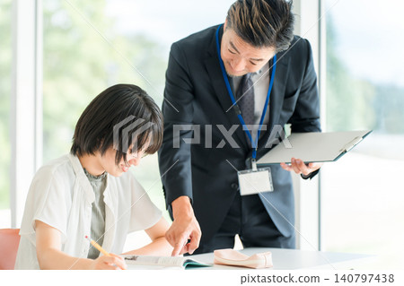 Elementary school children studying at cram schools/after-school programs, attending classes at school, or taking summer courses, and male instructors/teachers (education). 140797438