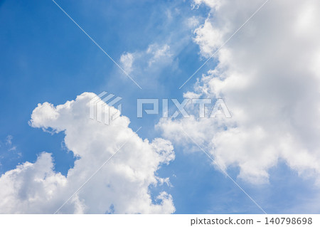 Dynamic white clouds rising up, framing the blue sky. 140798698