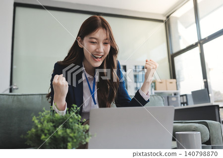 Asian businesswoman sitting at work using laptop talking and consulting in office 140798870