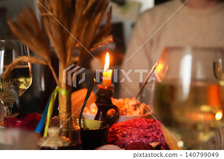 Traditional Ukrainian Christmas Eve dinner table with didukh, candle light and authentic food. Holy evening festive supper, national winter holiday celebration, and religious traditions concept Traditional Ukrainian Christmas Eve dinner table with didukh, candle light and authentic food. Holy evening festive supper, national winter holiday celebration, and religious traditions concept 140799049